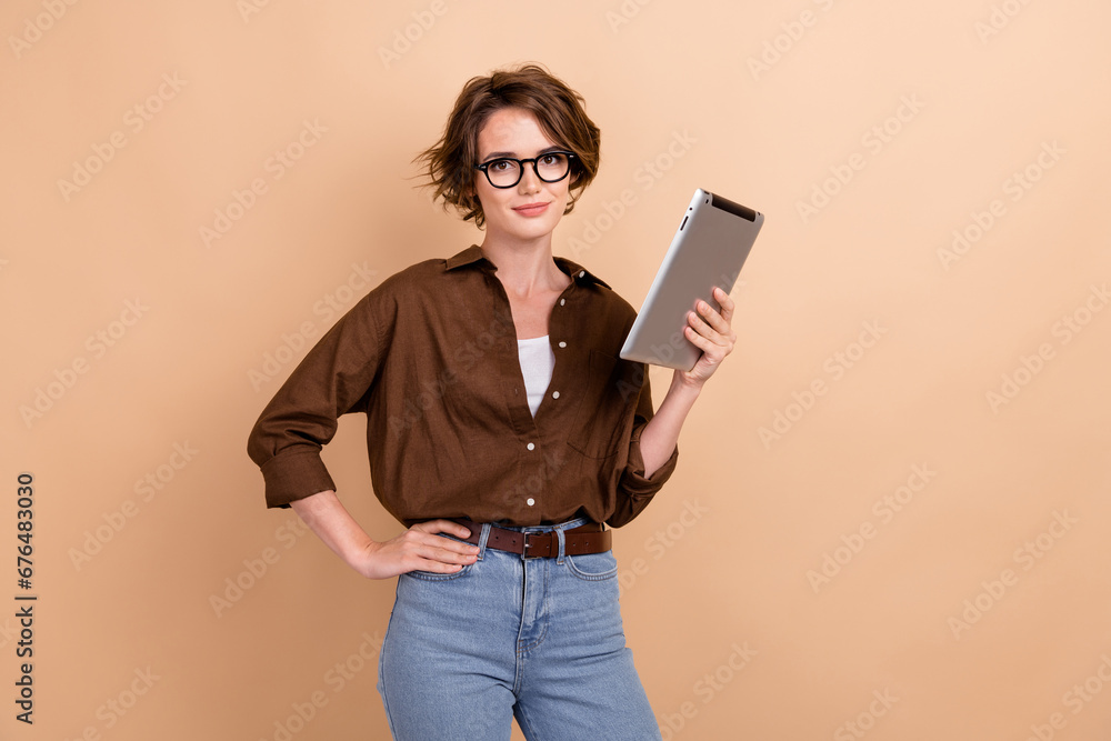 Photo of clever confident lady wear brown shirt spectacles communicating modern device isolated beige color background Photo of clever confident lady wear brown shirt spectacles communicating modern device isolated beige color background