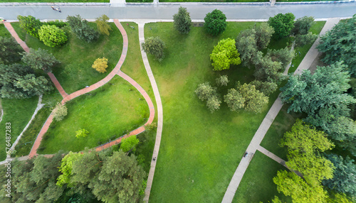 urban park with meadow trees and paths top view aerial photo from flying drone of a city park with walking path and green zone trees in evening time