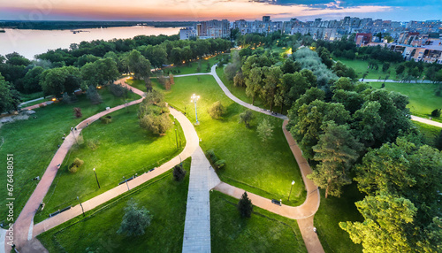 top view aerial photo from flying drone of a city park with walking path and green zone trees in evening time urban park with meadow trees and paths photo