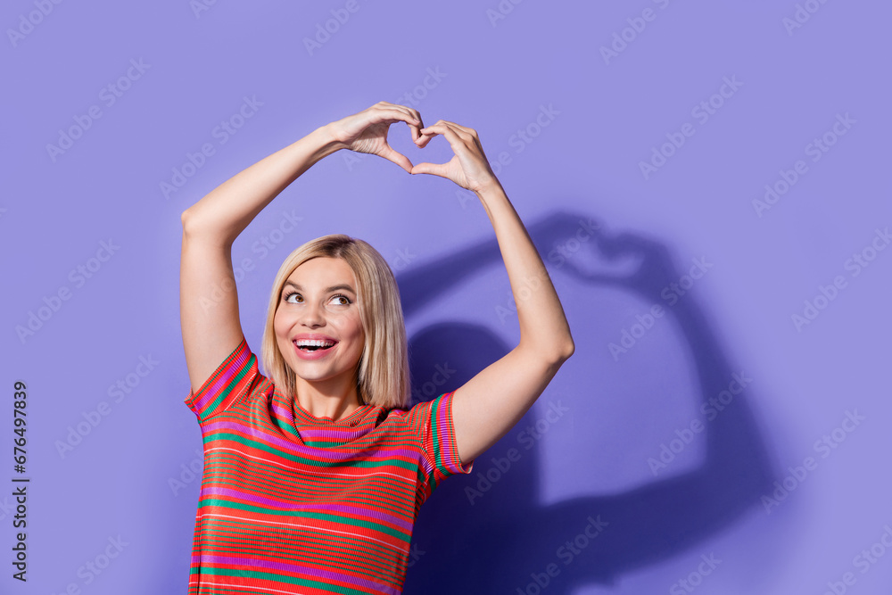 Fototapeta premium Portrait of young dreamy pretty girlfriend show heart symbol looking curious valentine day greetings isolated on violet color background