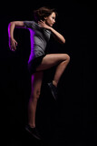Teen girl athlete jumping against black background. Magenta motion blur is added purposefully