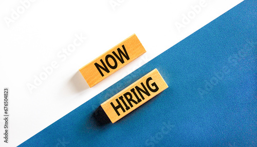 Now hiring symbol. Concept words Now hiring on beautiful wooden block. Beautiful white and blue background. Business marketing, motivational now hiring concept. Copy space.