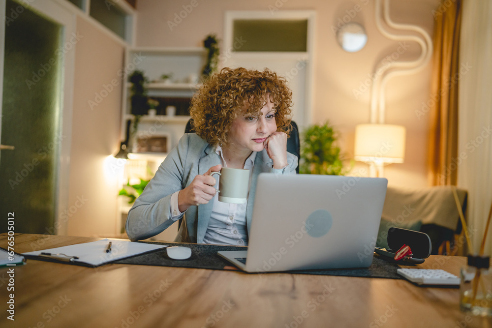 One woman caucasian mature female sit at the desk at work worried One woman caucasian mature female sit at the desk at work worried