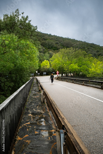 Hispanic man walks on road, autumnal landscape, cloudy weather