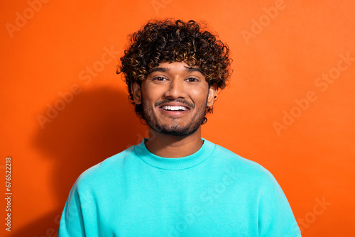 Portrait of cheerful funky friendly young man beaming smile good mood isolated on orange color background © deagreez