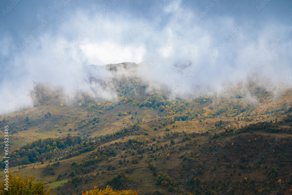 Thick clouds slide down from the mountains and are swirled by the wind.