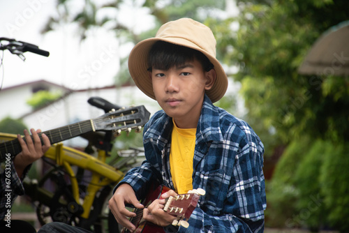 Asian cute boy with ukulele, children with popular instruments concept.