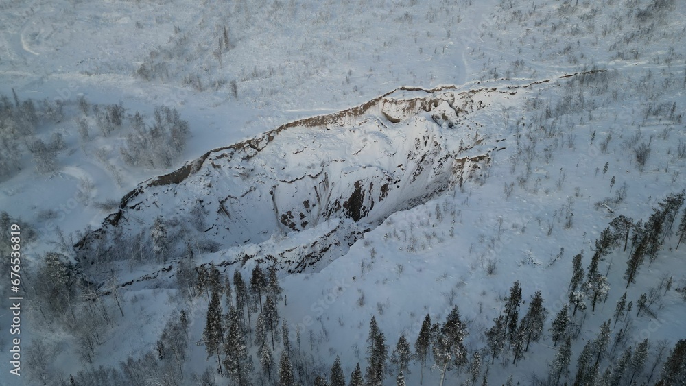 Obraz premium Aerial view of white snow-covered rural field and valleys