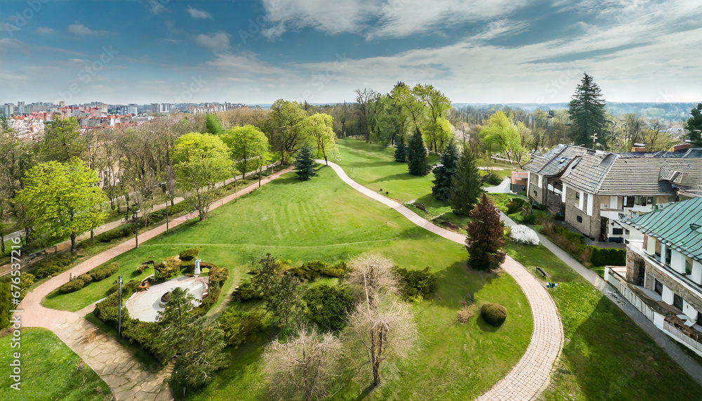 aerial top view of spring park landscape with green trees lawns and footpath park is surrounded by with houses green space city park aerial drone view high above