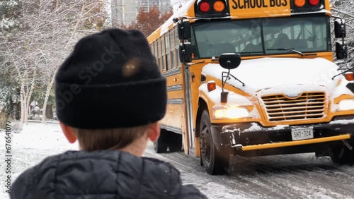 Young boy waits for the school bus in the winter
