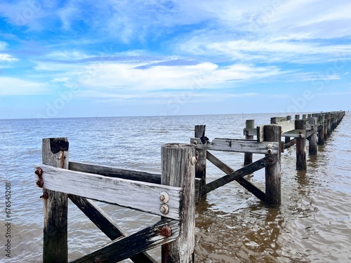 A weathered and broken down pier leading into the Gulf of Mexico,