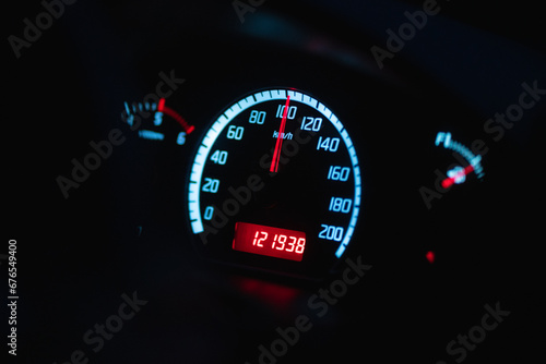 Close up of car speed meter showing 100km per hour driving at night