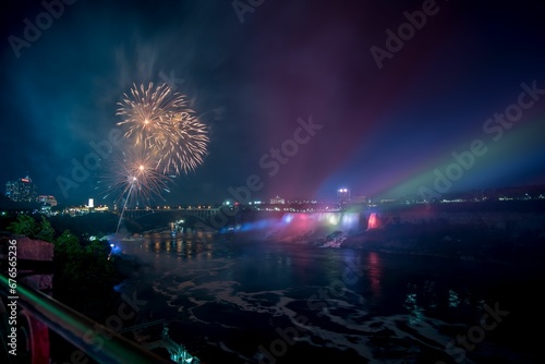 Fireworks in a distance at night in Niagara Falls city by water in Canada