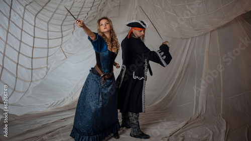 A lady with a dagger and a pirate in an old doublet with a saber, a battle with enemies, a pirate story © Ulia Koltyrina