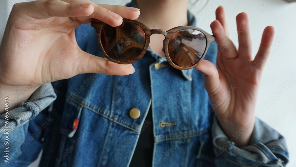 Fototapeta premium Fashionable woman holding a brown sunglasses
