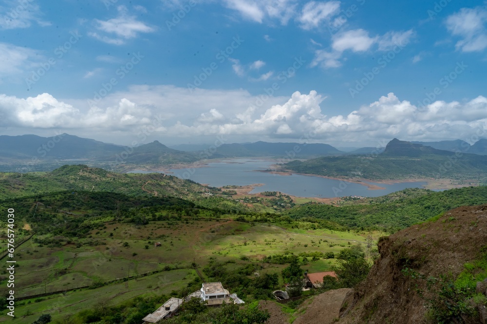 Aerial shot of Lake Pawna surrounded by hills and green fields on a sunny day, India Aerial shot of Lake Pawna surrounded by hills and green fields on a sunny day, India