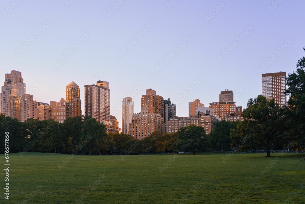 View of the urban buildings of New York City from Central Park at sunset