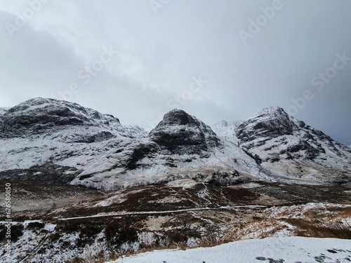 Scenic view of rocky mountain range covered with snow patches