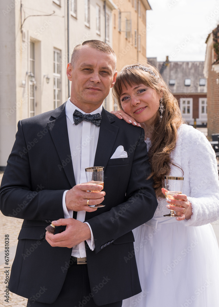 The bride and groom after the ceremony are holding a glass of champagne in their hands. Celebration of the occasion. Wedding The bride and groom after the ceremony are holding a glass of champagne in their hands. Celebration of the occasion. Wedding