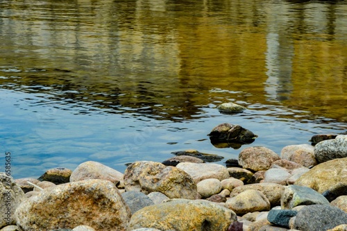 Rocks on the edge of a lake with calm waters during the daytime