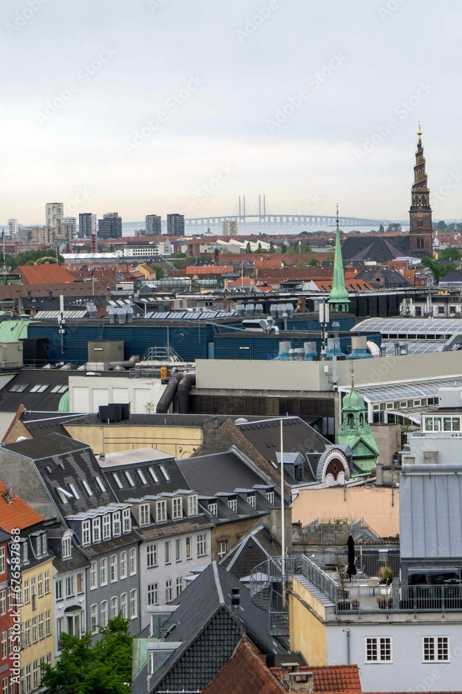 Vertical drone shot of buildings, the Church of the Savior and the Oresund Bridge in Copenhagen Vertical drone shot of buildings, the Church of the Savior and the Oresund Bridge in Copenhagen