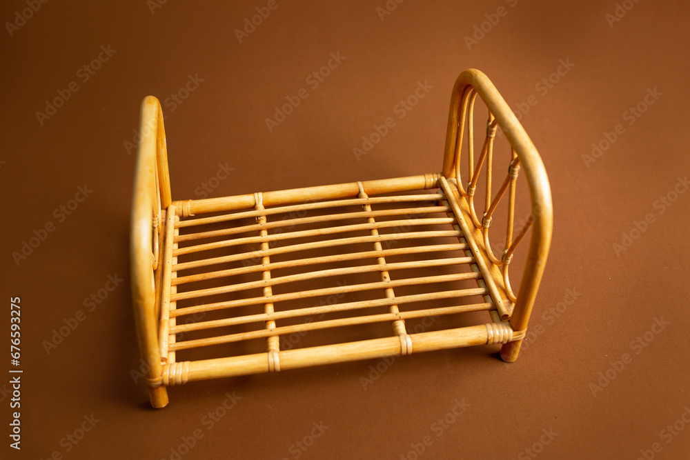 Fototapeta premium small bamboo bed. crib for a newborn photo shoot. Children's bed. bed for dolls