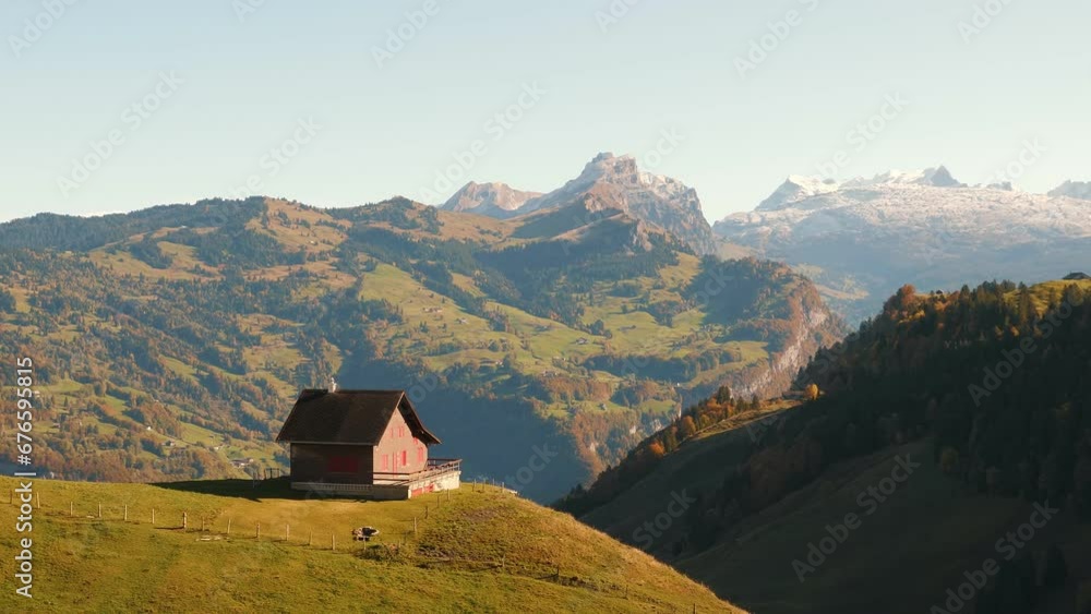 Picturesque panorama of Swiss Alps and small house standing on edge of hill Picturesque panorama of Swiss Alps and small house standing on edge of hill