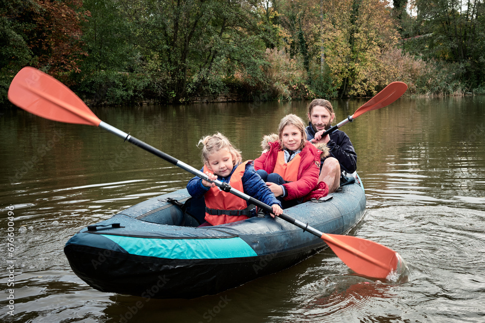 Harmonie aquatique, papa et deux filles sur un kayak Harmonie aquatique, papa et deux filles sur un kayak
