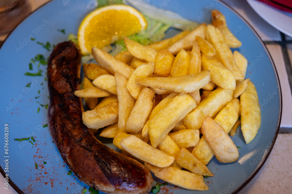 Fried fries potatoes with grilled meat German sausage served in old restaurant in Germany Fried fries potatoes with grilled meat German sausage served in old restaurant in Germany