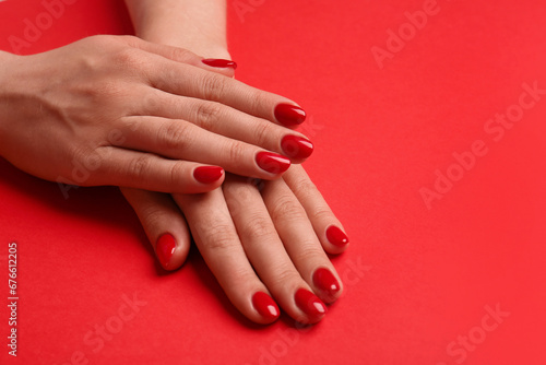 Woman with gel polish on nails on red background, closeup. Space for text