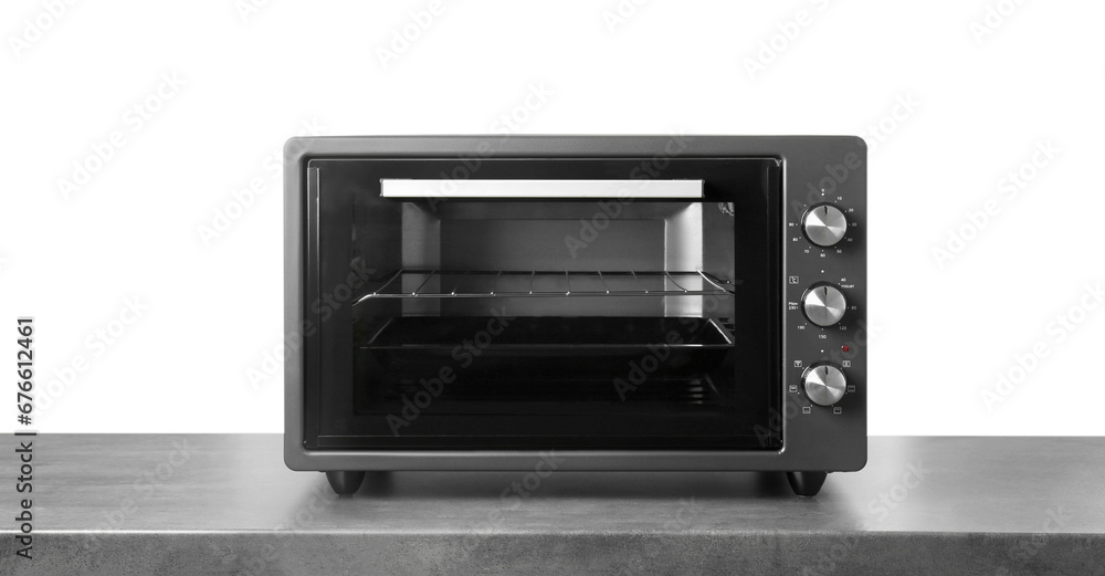 Fototapeta premium One electric oven on grey table against white background