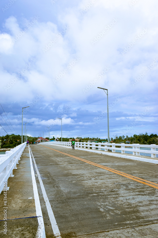 Crossing the bridge in a small town. Portrait. Magdiwang, Romblon, Philippines