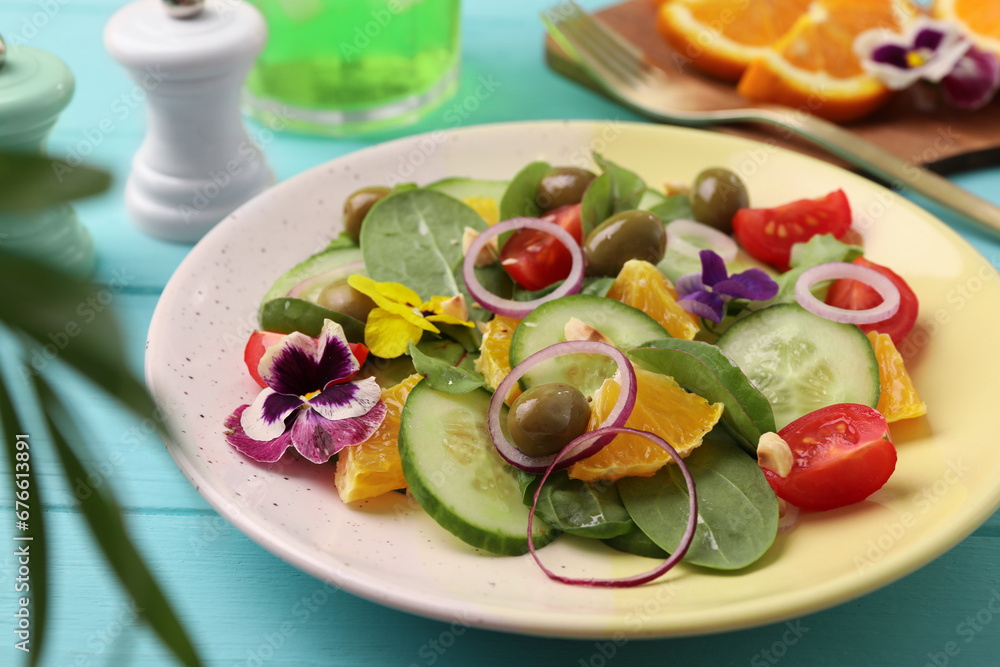 Delicious salad with orange, spinach, olives and vegetables served on turquoise wooden table, closeup Delicious salad with orange, spinach, olives and vegetables served on turquoise wooden table, closeup