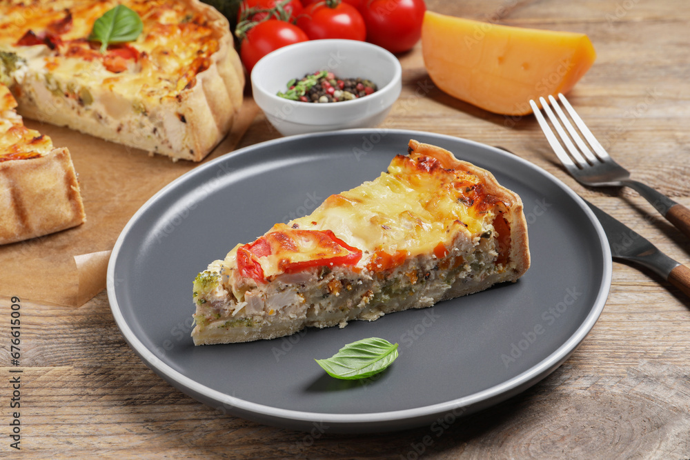 Tasty quiche with tomatoes, basil and cheese served on wooden table, closeup Tasty quiche with tomatoes, basil and cheese served on wooden table, closeup