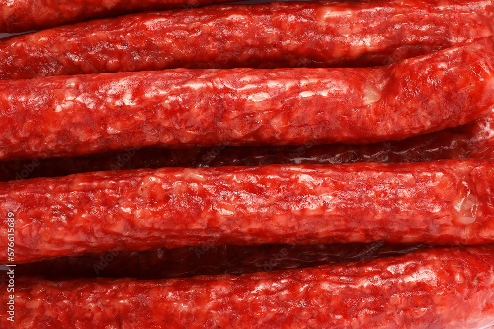 Many thin dry smoked sausages as background, top view