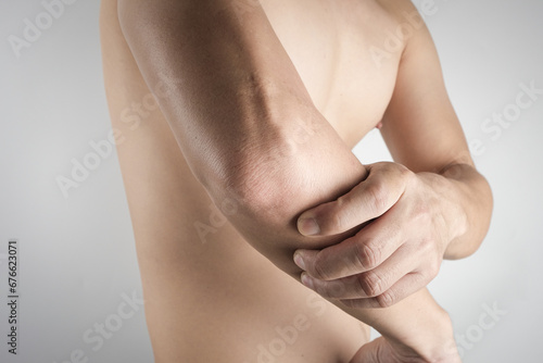A man has pain in his elbow and tendon muscles and he relieves the pain with a massage. Health and healing concept photo