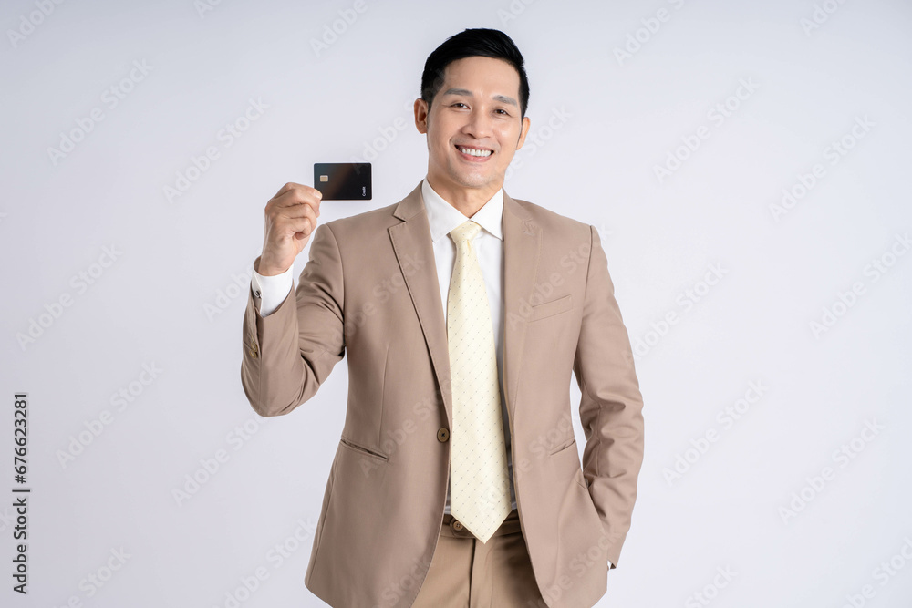 Image of Asian male businessman holding card credit on white background Image of Asian male businessman holding card credit on white background