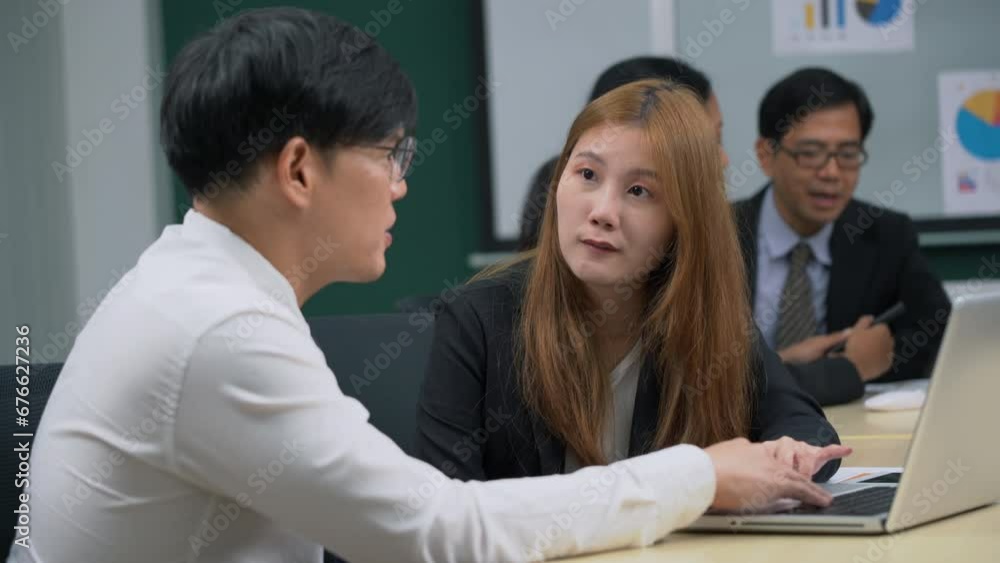 asian business manager man sitting on table teaching and talking to new employee young worker woman in office . colleagues discussing project . brainstorming and training to trainee .