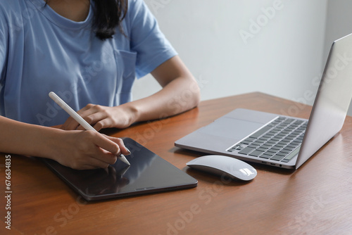 Female university student study in the school library.She using laptop and learning online, using tablet , sitting, laptop,