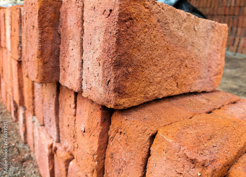 Selective focus. Red bricks from clay. Many clay is molded into bricks, after that it is laid out and dried in the yard in the sun before being burned to make it hard and dry. Pile of making batu bata