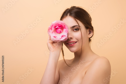 Tenderness and beauty. Happy smilig woman with spring flowers. Portrait of attractive lovely charming dreamy girl holding red roses, isolated on beige studio background. photo