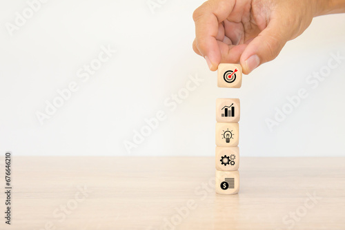 Hand choose cube wooden block stack pyramid with bull eyes target goal win and business strategy icon for growth and financial marketing analysis or human resource management and investment concepts.