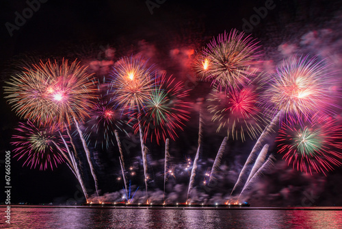 Amazing Colorful Fireworks exploding for Celebration from the big boat over the sea, celebration and happy new year and merry christmas festival concept