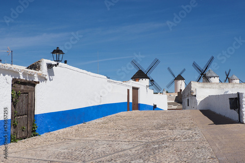 typical country street of campo de criptana with windmills in the background photo