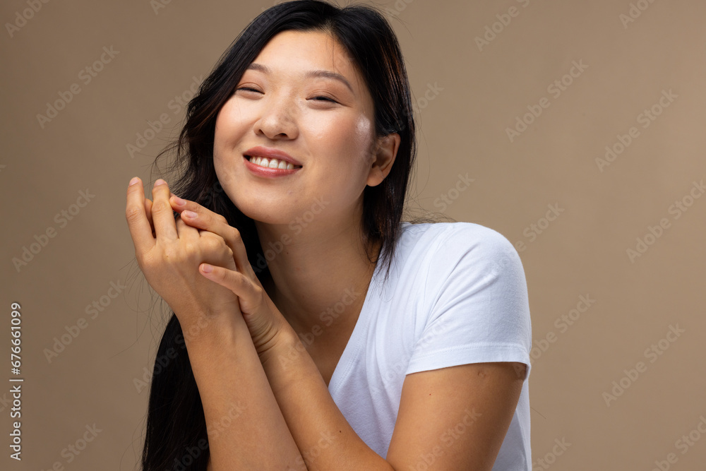 Portrait of asian woman wearing natural makeup and white t-shirt on beige background Portrait of asian woman wearing natural makeup and white t-shirt on beige background