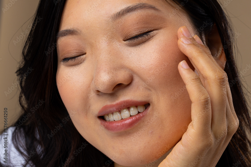 Asian woman wearing natural makeup and white t-shirt on beige background Asian woman wearing natural makeup and white t-shirt on beige background