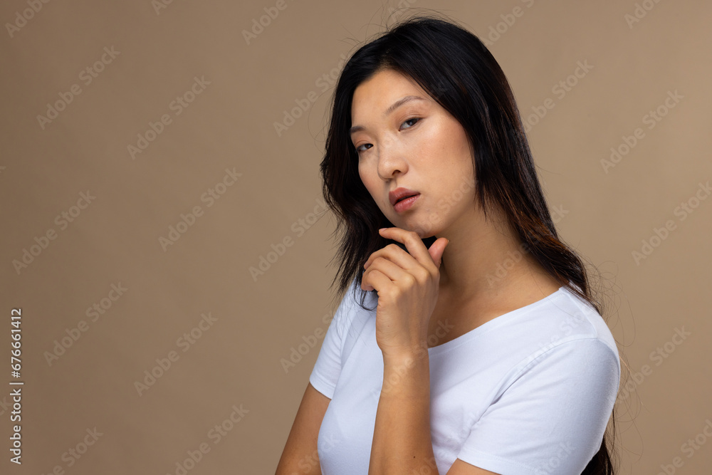Portrait of asian woman wearing natural makeup and white t-shirt on beige background, copy space Portrait of asian woman wearing natural makeup and white t-shirt on beige background, copy space