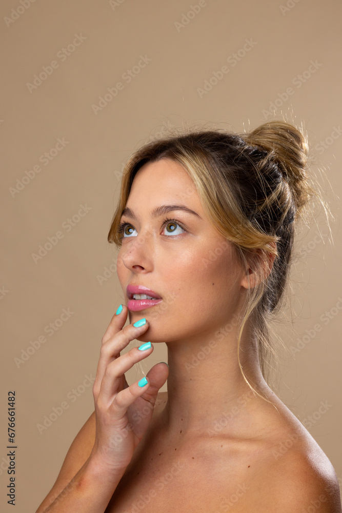Caucasian woman wearing natural makeup and blue nail polish on beige background, copy space Caucasian woman wearing natural makeup and blue nail polish on beige background, copy space