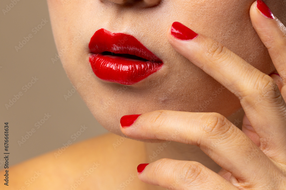 Naklejka premium Asian woman wearing red lipstick and nail polish on beige background