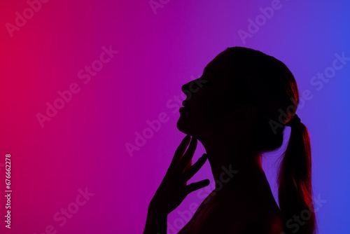 Silhouette of caucasian woman on purple background, copy space